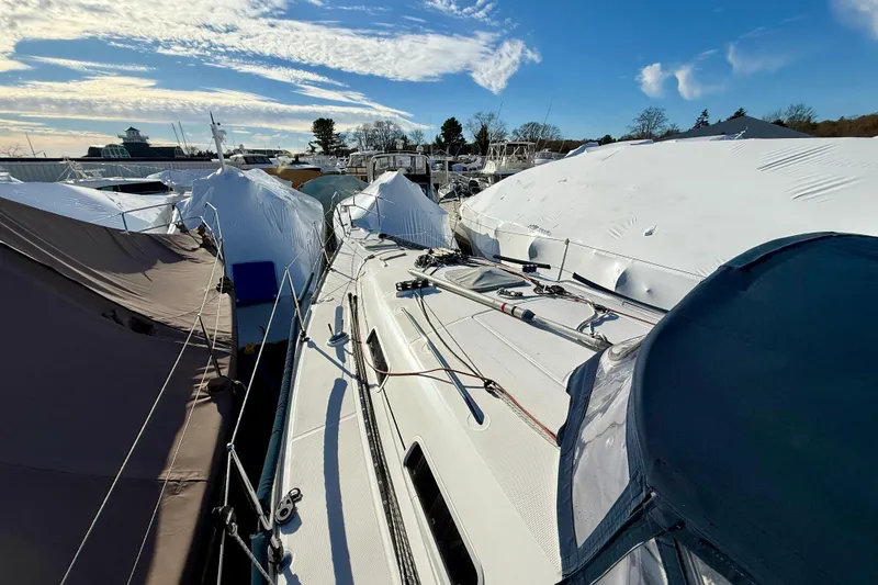 Slide: The Image of 2005 Beneteau First 36.7 sailboat docked, covered for winter storage under a clear blue sky. - 3