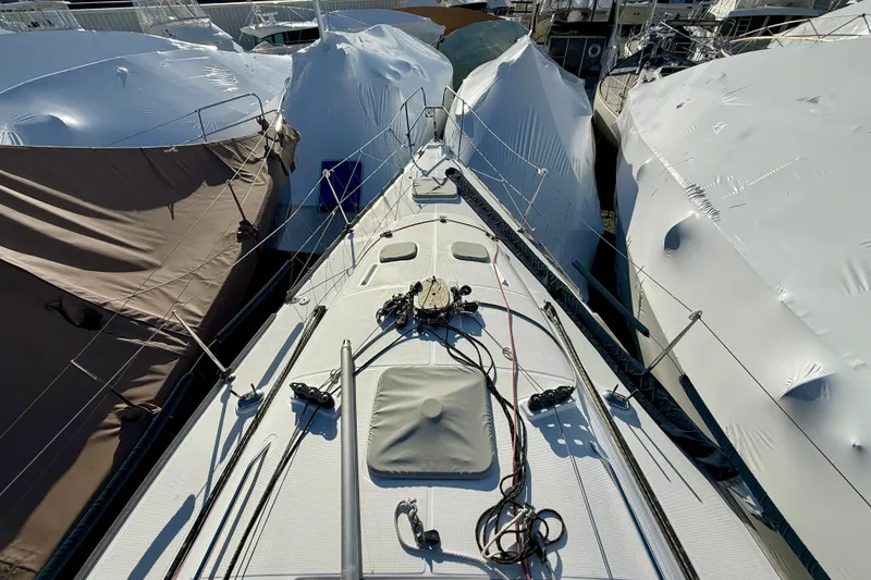 Slide: The Image of Deck view of a 2005 Beneteau First 36.7 sailboat, surrounded by covered boats. - 5