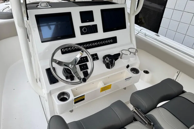 Slide: The Image of 2026 Key West 263 FS boat dashboard with steering wheel and dual screens. - 13