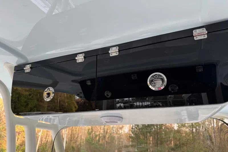 Slide: The Image of 2026 Key West 263 FS boat storage compartment with secure latches and sleek design. - 15