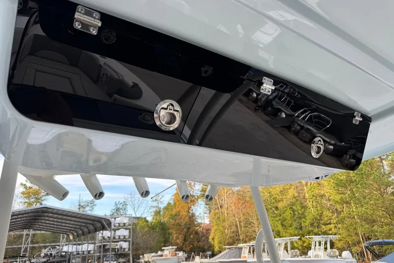 Slide: The Image of 2026 Key West 263 FS boat storage compartment with secure latches, docked in a marina. - 16