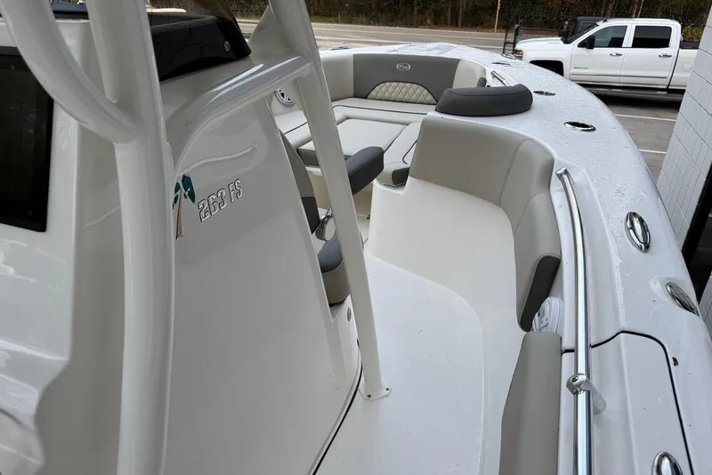 Slide: The Image of 2026 Key West 263 FS boat interior with seating and console, parked near a white truck. - 21