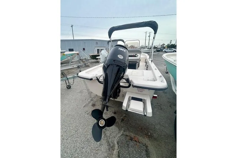 Slide: The Image of 2026 Carolina Skiff E20 JVX CC boat with outboard motor, parked on a lot. - 8