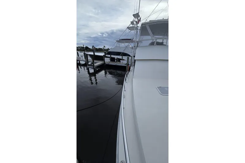 Slide: The Image of 1989 Viking 45 Convertible yacht docked at marina under cloudy sky. - 15