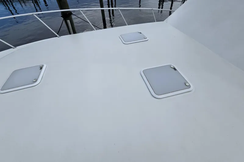 Slide: The Image of 1989 Viking 45 Convertible yacht deck with hatches, docked by the water. - 16