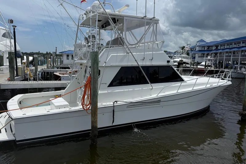 Slide: The Image of 1989 Viking 45 Convertible boat with blue underwater lights at night, named "Wild Life." - 2