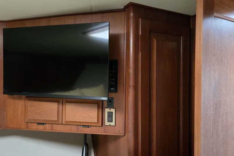 Slide: The Image of Flat-screen TV mounted on wood paneling inside a 1989 Viking 45 Convertible boat. - 23
