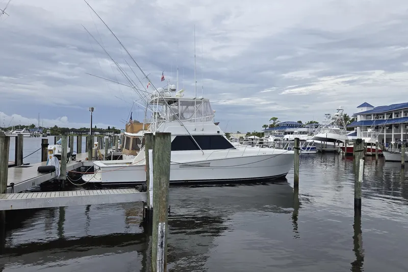 Slide: The Image of 1989 Viking 45 Convertible yacht docked at marina under cloudy sky. - 3