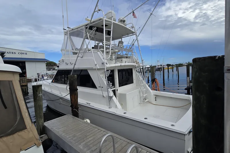 Slide: The Image of 1989 Viking 45 Convertible yacht docked at marina under cloudy sky. - 7