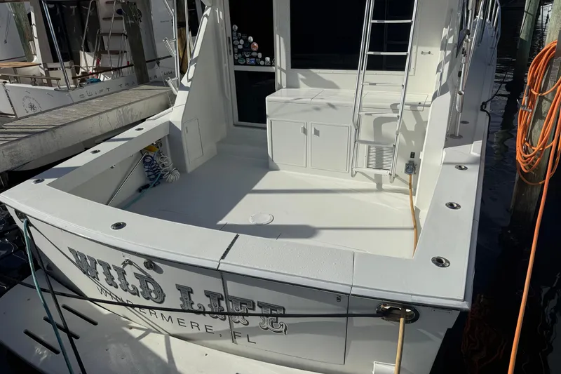 Slide: The Image of 1989 Viking 45 Convertible boat docked, featuring spacious deck and ladder. - 9