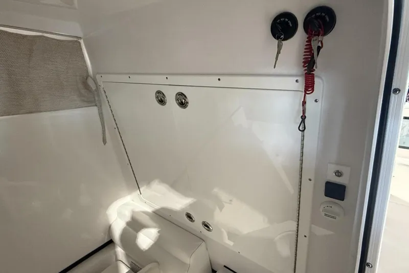 Slide: The Image of Interior view of 2025 Sportsman Open 322 Center Console boat, featuring storage and key hooks. - 12