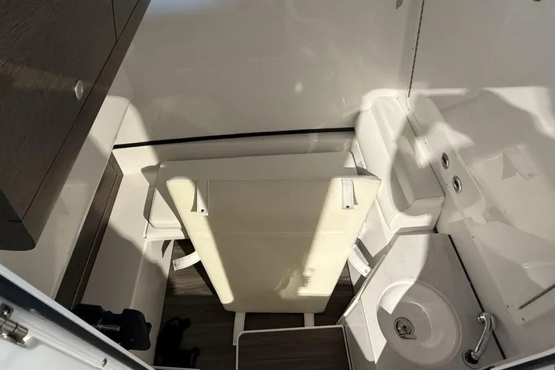 Slide: The Image of Interior of 2025 Sportsman Open 322 Center Console boat, featuring compact bathroom amenities. - 14