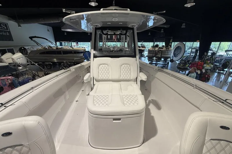 Slide: The Image of 2025 Sportsman Open 322 Center Console boat interior with white seating in showroom. - 18