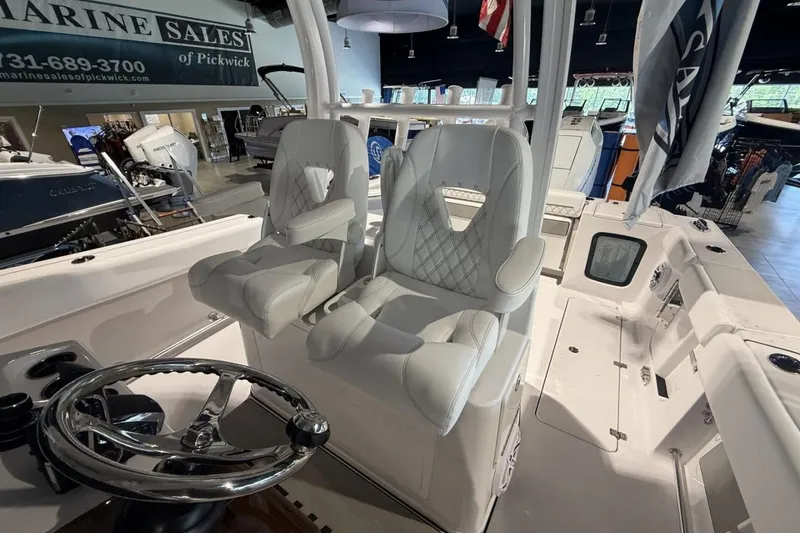 Slide: The Image of 2025 Sportsman Open 322 Center Console boat interior with luxury seating and steering wheel. - 19