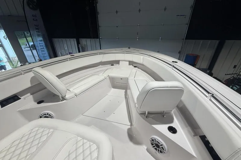 Slide: The Image of 2025 Sportsman Open 322 Center Console boat interior with white seating and speakers. - 20