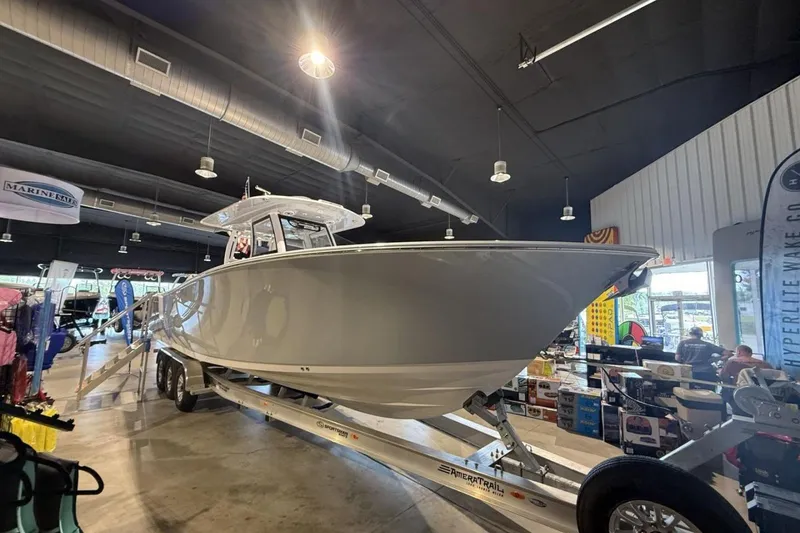 Slide: The Image of 2025 Sportsman Open 322 Center Console boat displayed indoors on a trailer. - 4