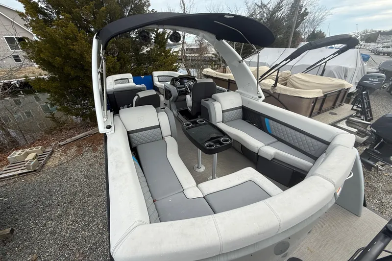 Slide: The Image of 2023 Godfrey AquaPatio 255 ULC pontoon boat with spacious seating, docked at marina. - 15