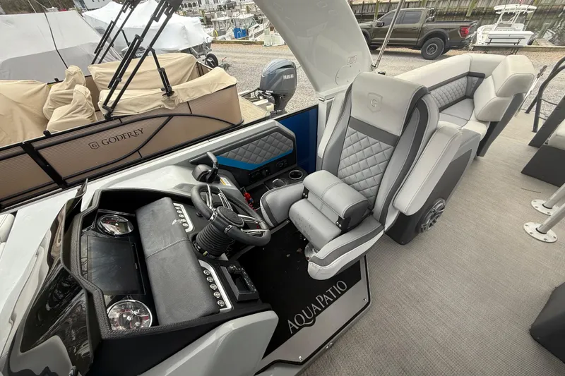 Slide: The Image of 2023 Godfrey AquaPatio 255 ULC pontoon boat interior with luxury seating and helm. - 18