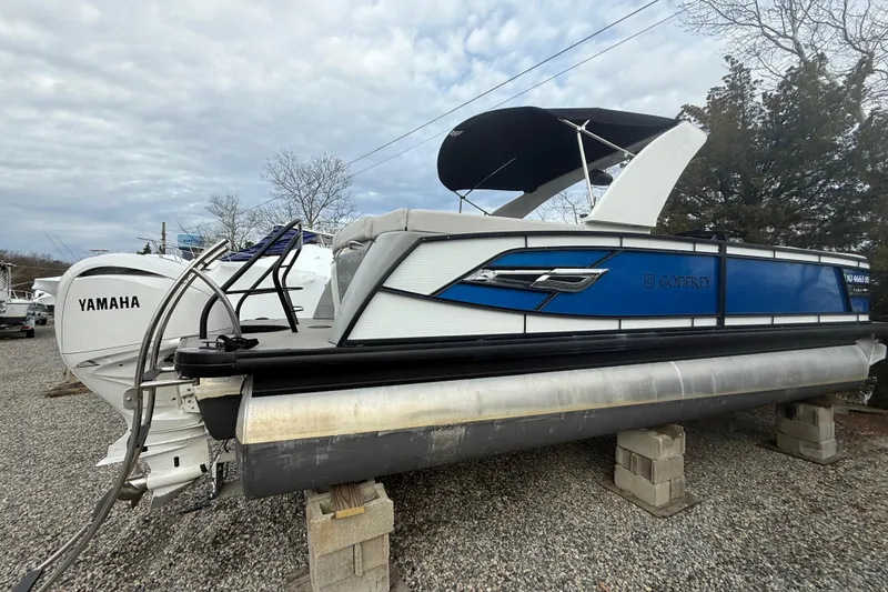 Slide: The Image of 2023 Godfrey AquaPatio 255 ULC pontoon boat with Yamaha engine on display. - 2
