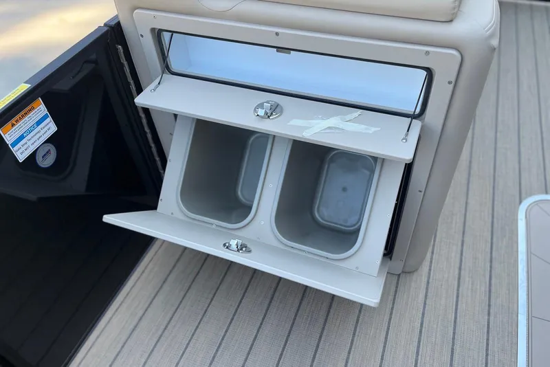 Slide: The Image of 2026 Godfrey SWEETWATER 2286 SFL boat storage compartment with open bins on deck. - 19