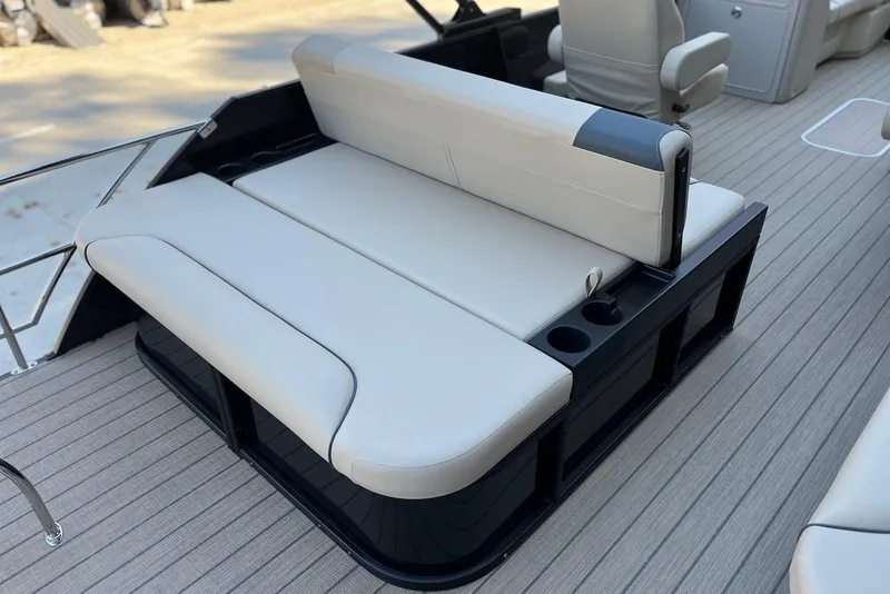 Slide: The Image of 2026 Godfrey SWEETWATER 2286 SFL boat interior with beige seating and cup holders. - 24