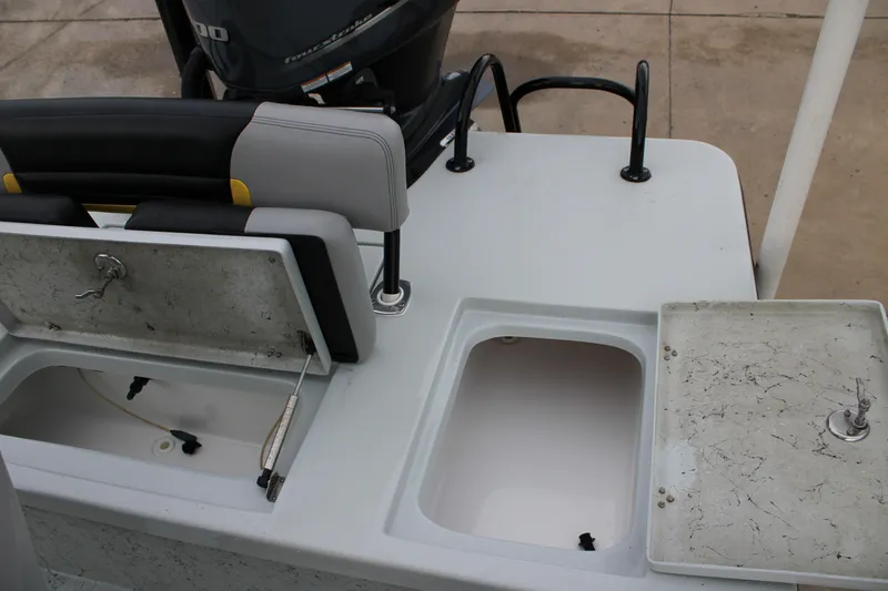 Slide: The Image of 2017 Blazer 2420 boat with open storage compartments and motor, showcasing seating and deck layout. - 13