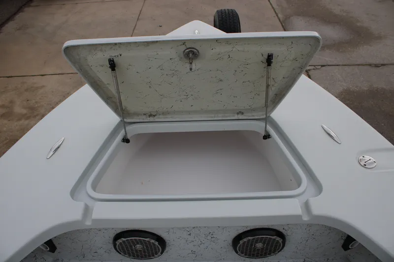 Slide: The Image of Open storage compartment on 2017 Blazer 2420 boat, showing interior and speakers. - 20