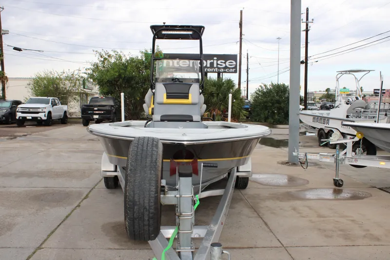 Slide: The Image of 2017 Blazer 2420 boat on trailer in parking lot, surrounded by vehicles and trees. - 21