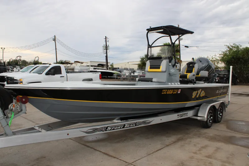 Slide: The Image of 2017 Blazer 2420 boat on trailer, parked outdoors with overcast sky. - 22