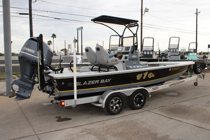 Slide: The Image of 2017 Blazer 2420 boat with Yamaha engine on a trailer, parked outdoors. - 5