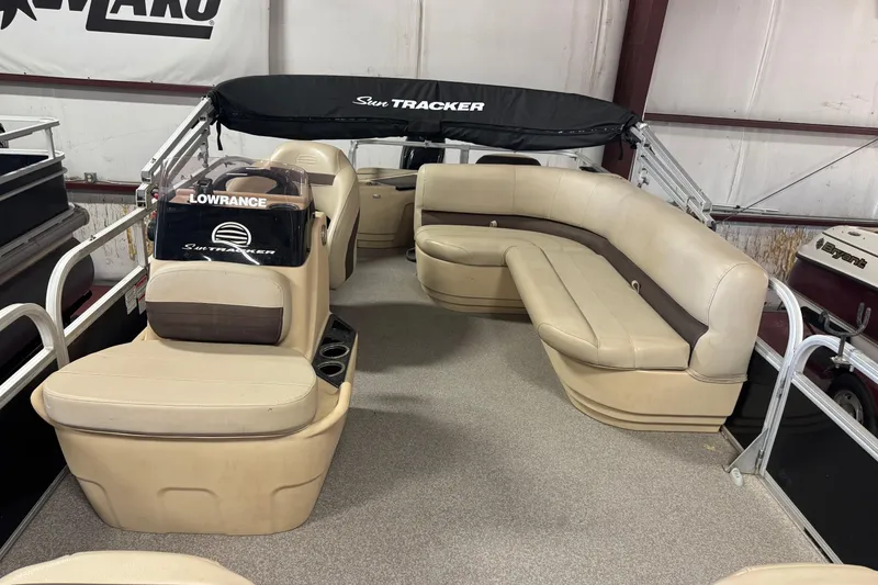 Slide: The Image of 2019 Sun Tracker Bass Buggy 18 DLX pontoon boat interior with beige seating and Lowrance equipment. - 3