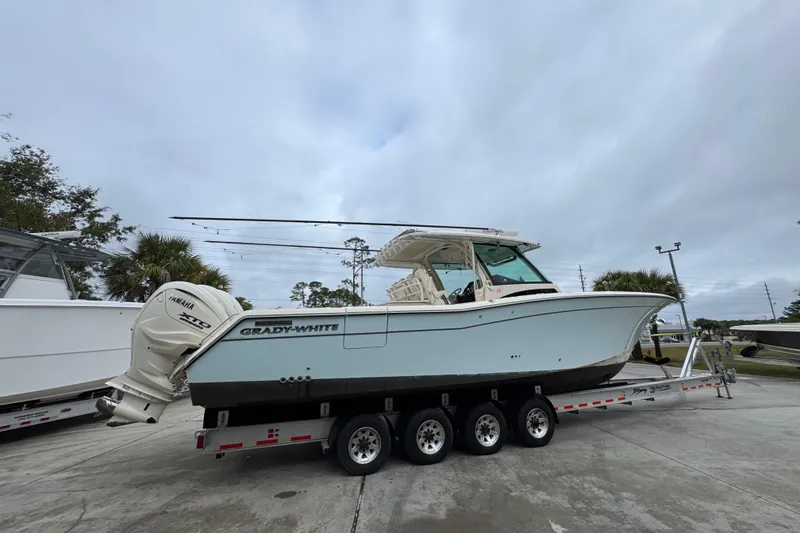 Slide: The Image of 2024 Grady-White Canyon 386 boat on trailer, featuring Yamaha engines, parked outdoors. - 13