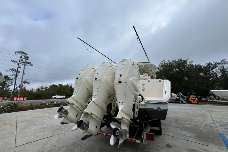 Slide: The Image of 2024 Grady-White Canyon 386 boat with triple outboard engines, parked outdoors. - 16