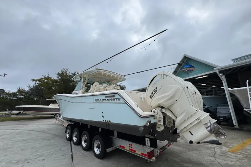 Slide: The Image of 2024 Grady-White Canyon 386 boat on trailer, featuring powerful outboard engines. - 19