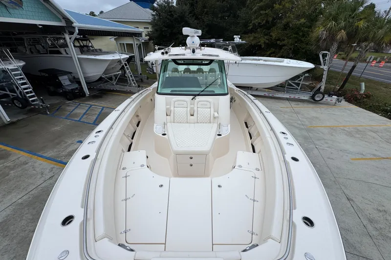 Slide: The Image of 2024 Grady-White Canyon 386 boat, docked, showcasing spacious deck and seating area. - 24