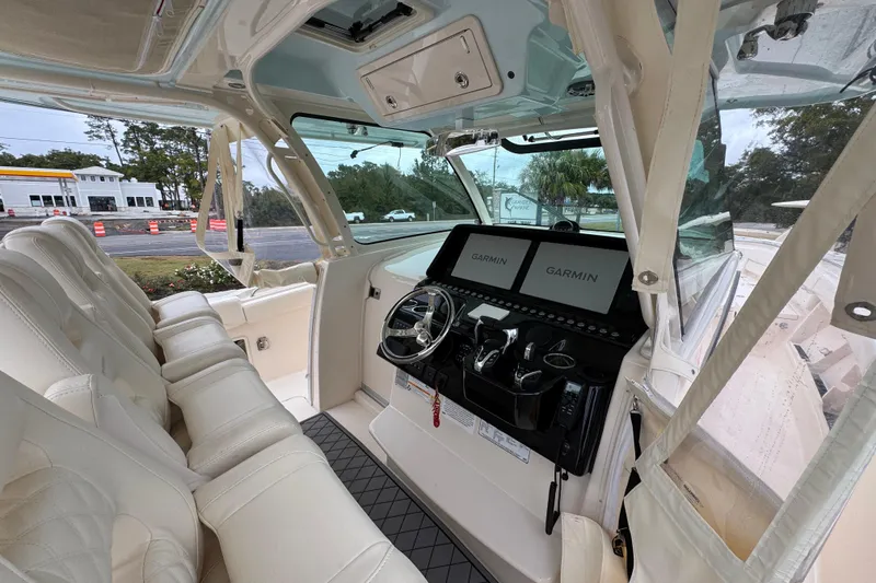 Slide: The Image of 2024 Grady-White Canyon 386 boat interior with Garmin navigation displays and luxurious seating. - 39