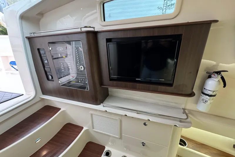 Slide: The Image of 2024 Grady-White Canyon 386 interior with control panel, TV, and fire extinguisher. - 43