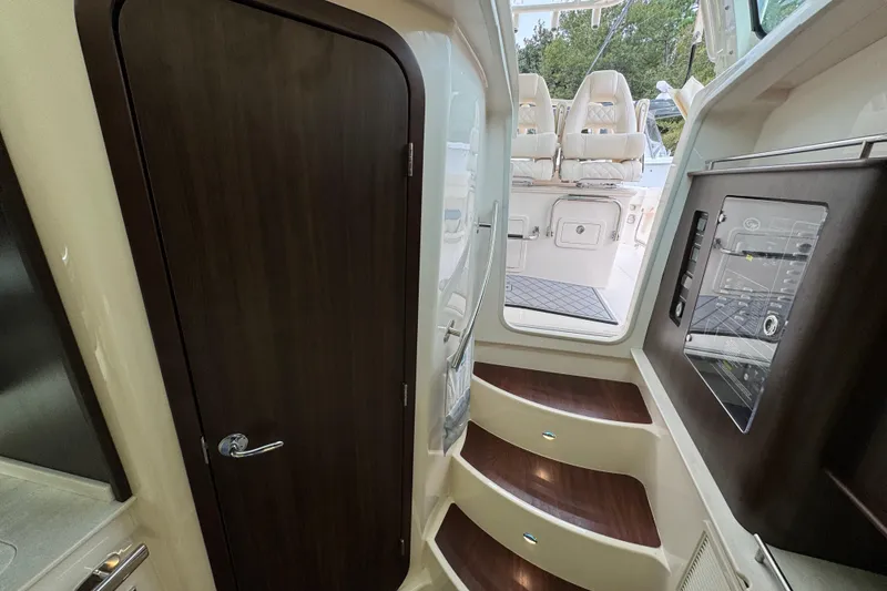 Slide: The Image of 2024 Grady-White Canyon 386 interior with wooden door, steps, and control panel. - 49