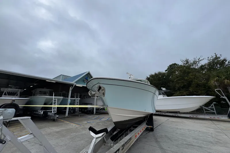 Slide: The Image of 2024 Grady-White Canyon 386 boat on trailer at dealership, cloudy sky background. - 6