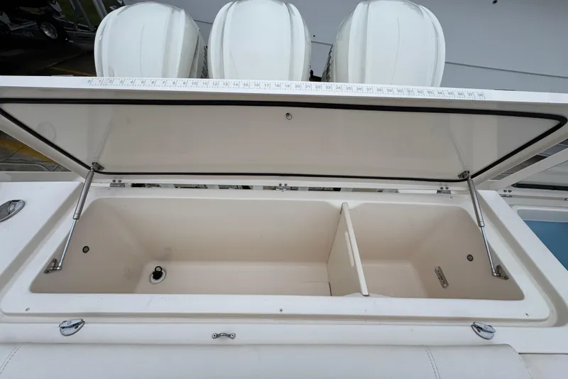 Slide: The Image of Open storage compartment on 2024 Grady-White Canyon 386 boat, featuring a divided interior. - 65