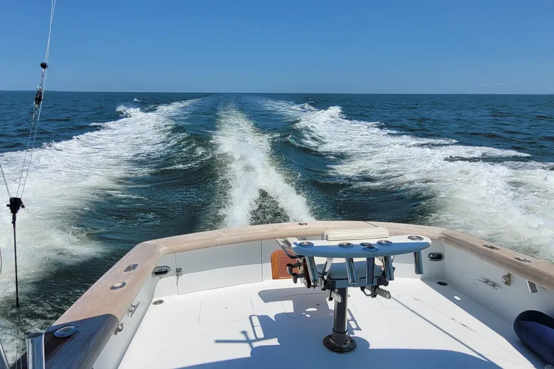 Slide: The Image of Sunny Briggs 37 Express boat cruising on open sea, leaving a foamy wake behind. - 16