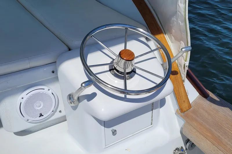 Slide: The Image of Steering wheel of 1984 Sunny Briggs 37 Express boat, with speaker and cushioned seating. - 4