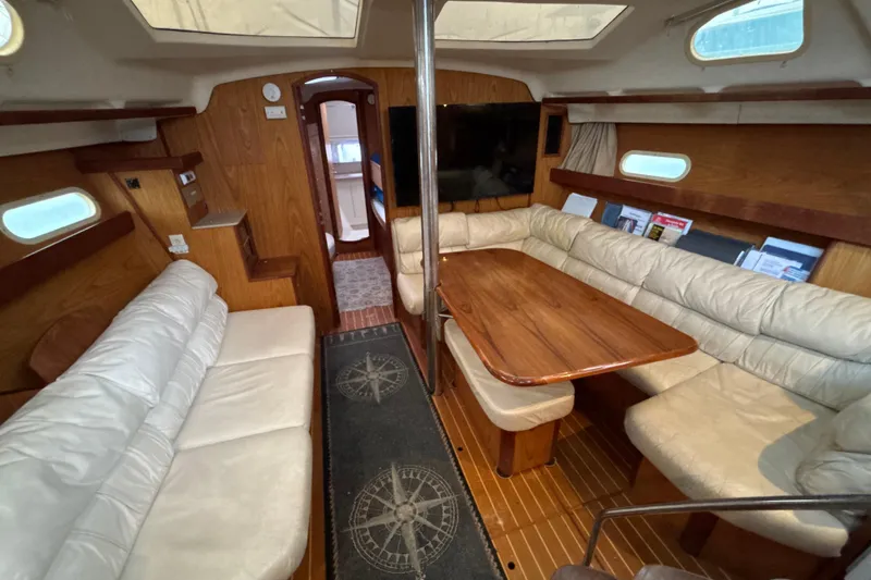 Slide: The Image of Interior of 2000 Hunter Passage 450 yacht with cozy seating and wooden table. - 18