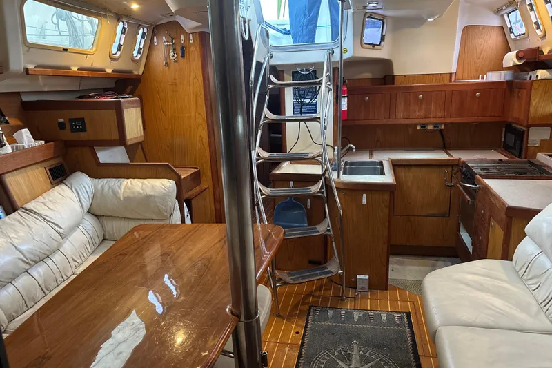 Slide: The Image of Interior of 2000 Hunter Passage 450 sailboat with wood finish and cozy seating area. - 19