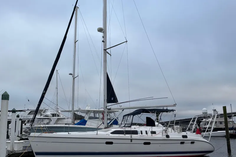 Slide: The Image of 2000 Hunter Passage 450 sailboat docked at marina under cloudy sky. - 2