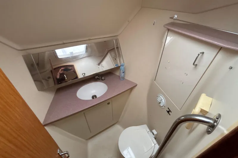 Slide: The Image of Bathroom interior of 2000 Hunter Passage 450 yacht, featuring sink, mirror, and toilet. - 21