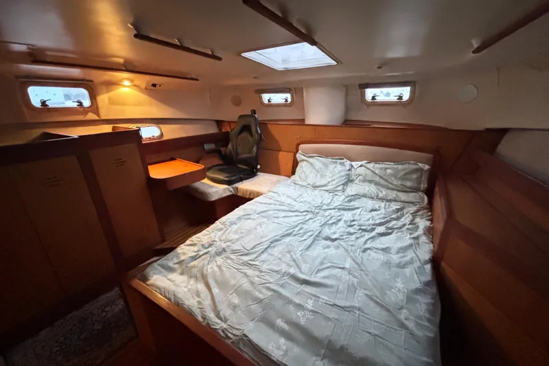 Slide: The Image of Cozy cabin interior of 2000 Hunter Passage 450 sailboat with bed and seating area. - 25