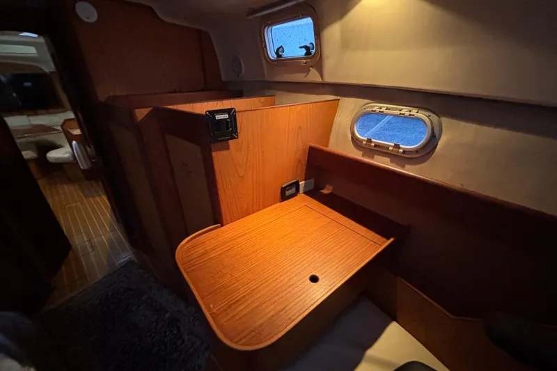 Slide: The Image of Interior of 2000 Hunter Passage 450 yacht with wooden cabinetry and porthole window. - 27