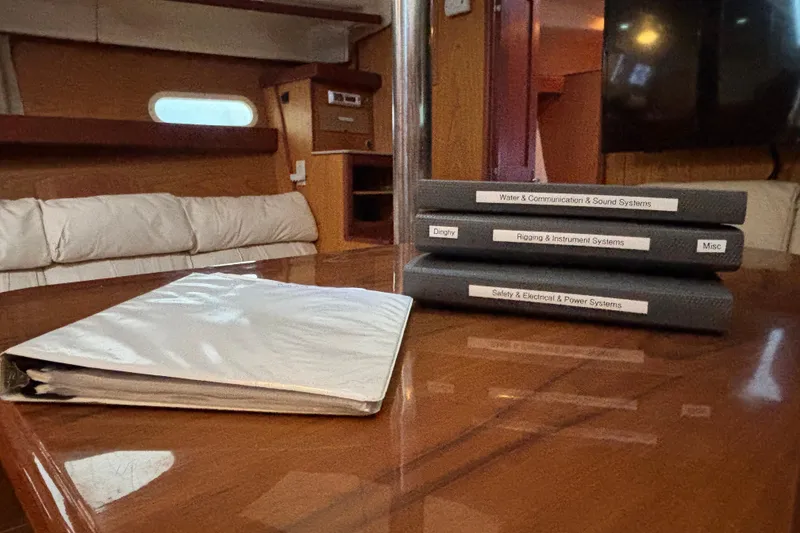Slide: The Image of Interior of 2000 Hunter Passage 450 yacht with manuals on a wooden table. - 31