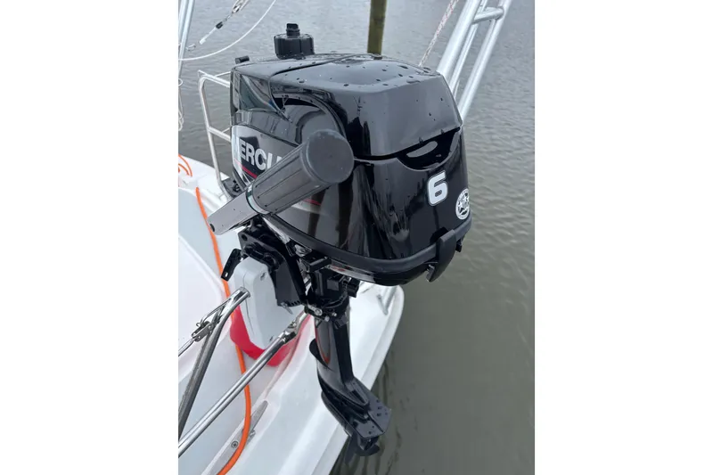 Slide: The Image of Outboard motor on 2000 Hunter Passage 450 sailboat, docked on calm water. - 32